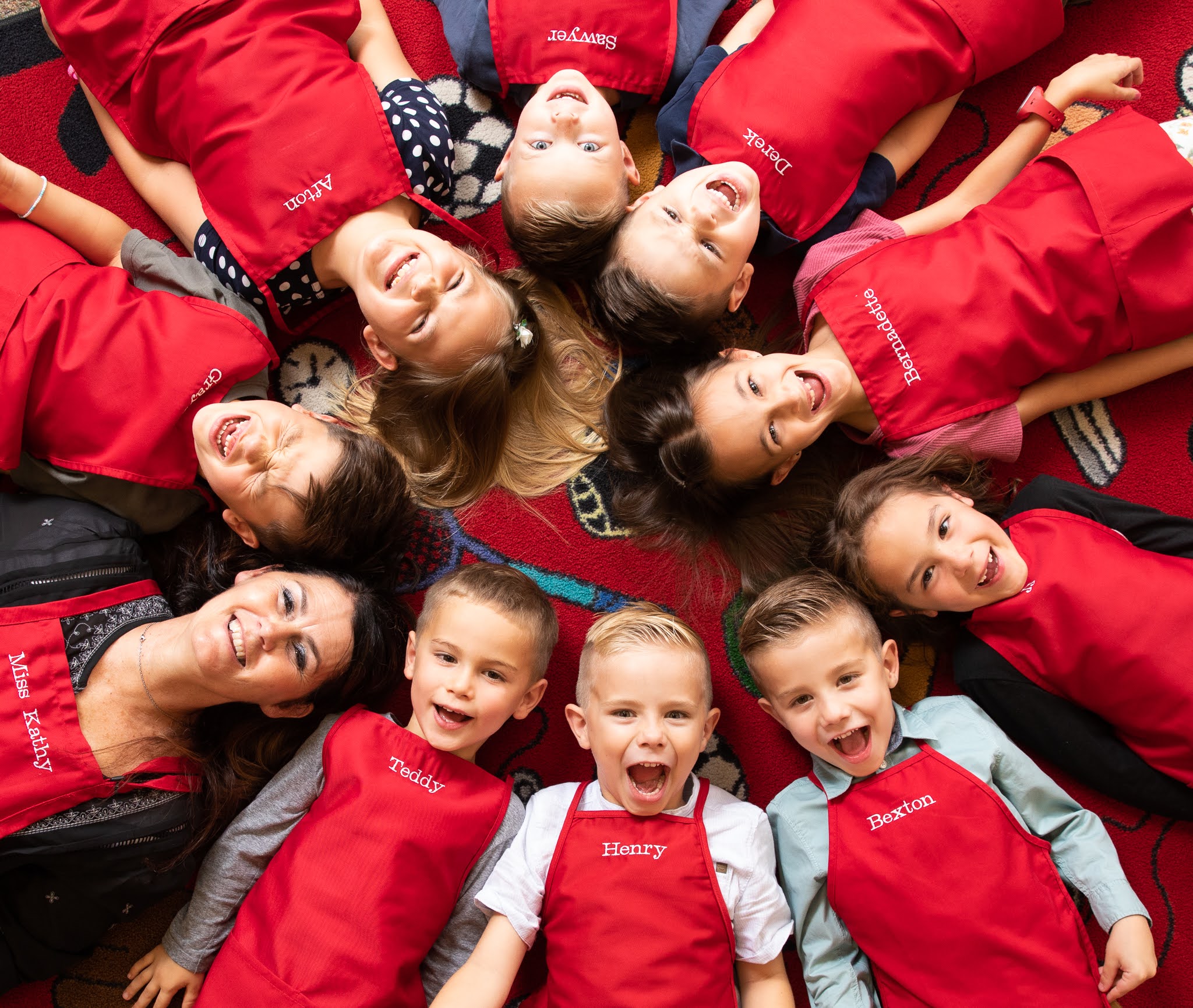 Children using good manners together while laying on rug