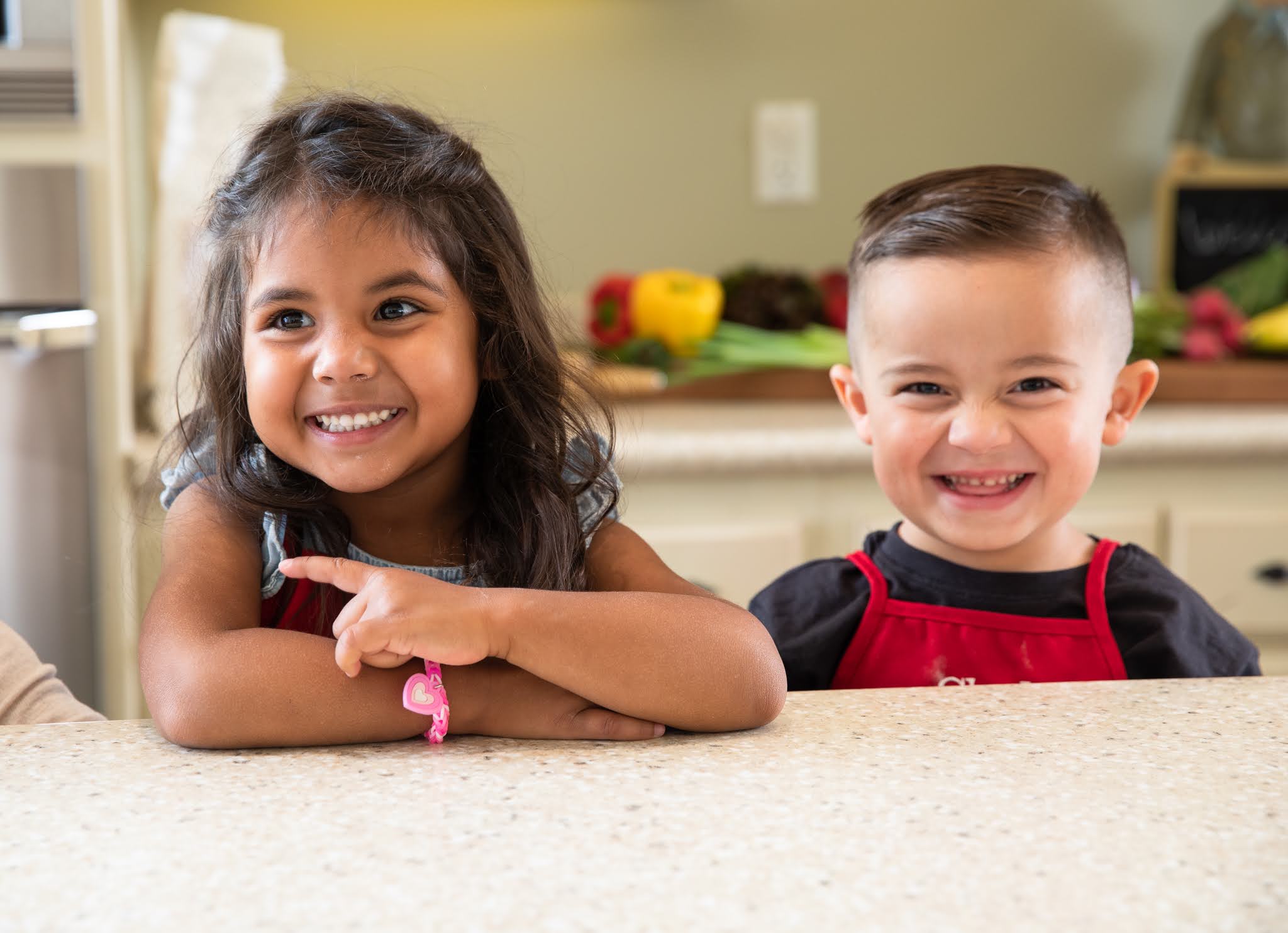 Young boy and girl standing at clean kitchen counter after doing chores