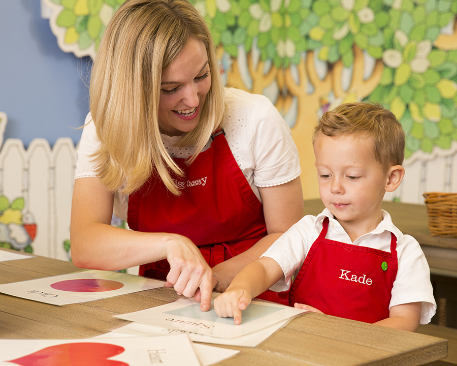 Teacher at private school Kids Village teaching a young student shapes