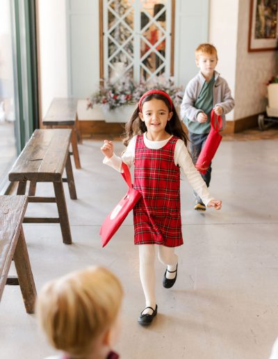 preschool child smiling and running through beautiful hallway at kids village private school in orem, utah