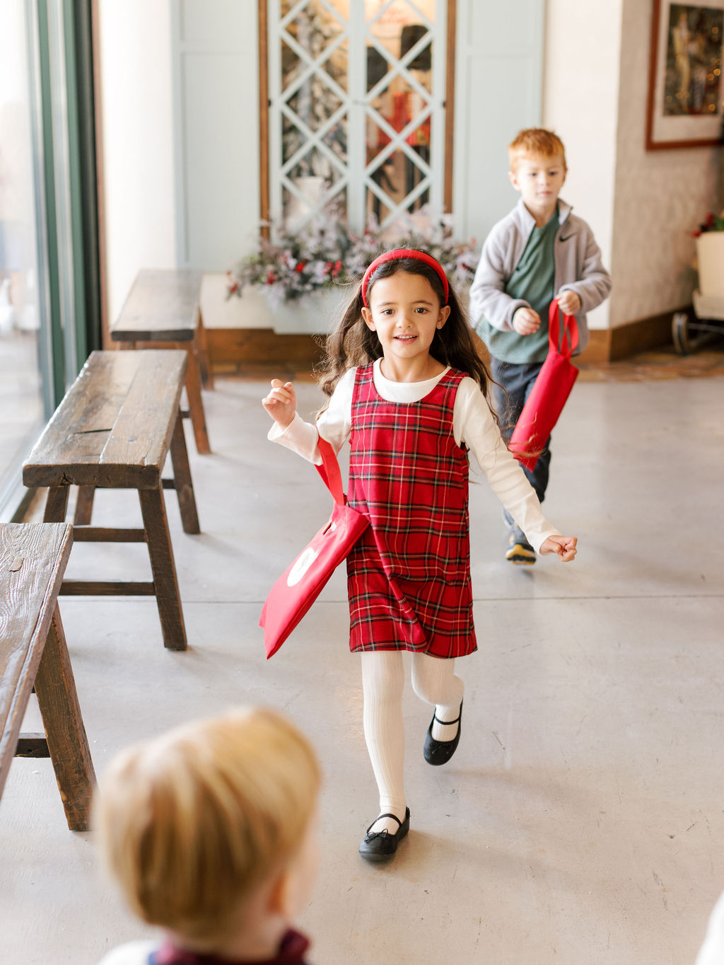 preschool child smiling and running through beautiful hallway at kids village private school in orem, utah